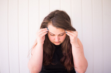 The young girl is upset and holds on to whiskey because of a pain in her head, because her psychological state is stressful.