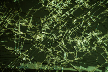 Broken glass of a phone with a crack as a cobweb close-up