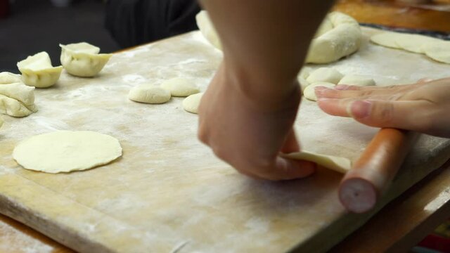Homemade dumpling wrappers, closeup, woman making dumpling wrappers with rolling pin