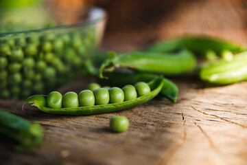 Close up of green peas on a wooden table. Rustic style.