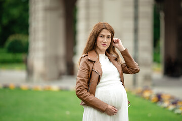 pregnant brunette woman at an old building gazebo.