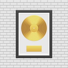 Gold vinyl record with black frame on white brick wall