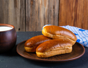 Breakfast rolls with chocolate filling and milk on a wooden rustic background