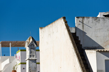 Fototapeta na wymiar traditional white openwork chimney on blue sky background in Algarve
