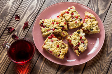liced ​​homemade grated pie with berries on a pink plate.