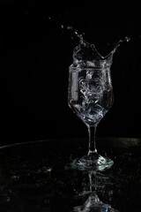 Fototapeta na wymiar A splash with water and ice on a black background