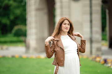 pregnant brunette woman at an old building gazebo.