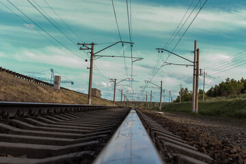 The railway tracks go off into the distance under the measured hum of wires.