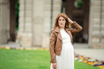 Fototapeta premium pregnant brunette woman at an old building gazebo.