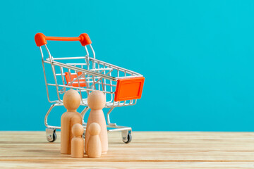Wooden figures of family and toy shopping cart. Shopping concept