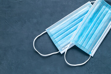 Close-up of two medical mask on a dark background. A symbol of a pandemic, individual protection, the infection protection concept. Horizontal orientation. View from above