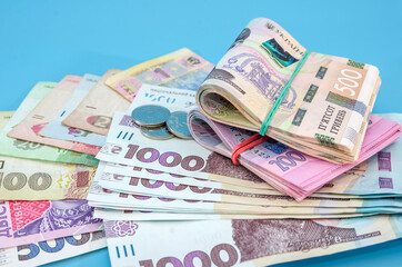 different hryvnias on a blue background. Much money. Financial concept.