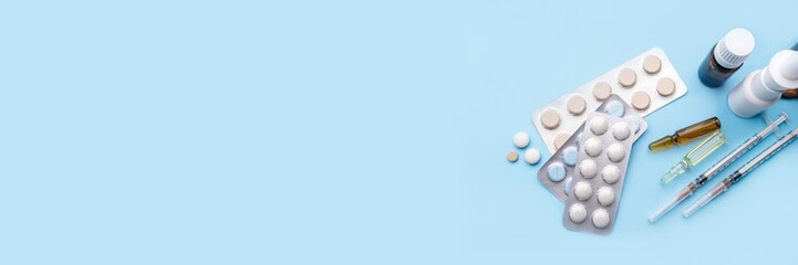 Tablets, pack of medicines with medicine bottles on a blue background. Pharmacy theme.