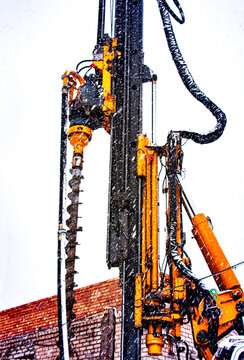 Drilling rig for piling device. Foundations and foundation. Blurred image on the background of falling snow. Work in the north. Difficult working conditions.