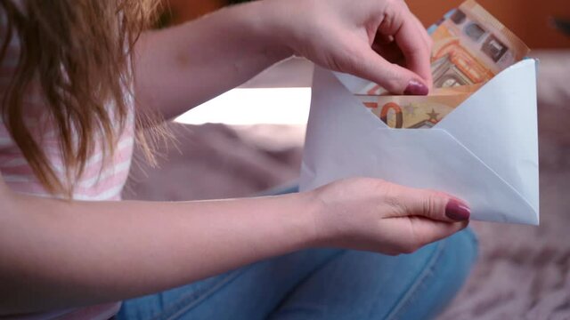 Female hands counting 50 euro banknotes from white envelope, cash money in evelope, employee salary. Euro currency exchange, cash money calculation. Paper currency profit and financial investment