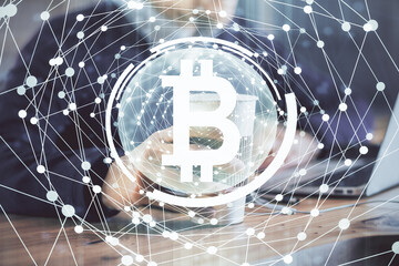 Crypto currency theme hologram with businessman working on computer on background. Concept of...