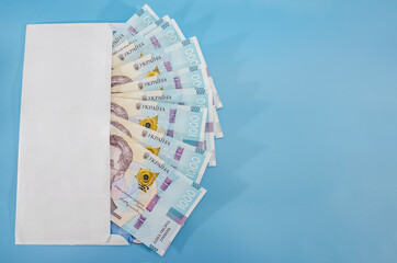 1000 hryvnia in a white envelope on a blue background. Copy of space. Place for text.