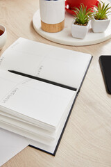 green plants, notebook with pencil on wooden surface