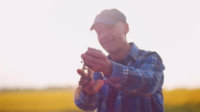 Farmer Examining Soild Dirt in Hands at Dusk