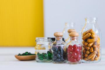 Close up pill and tablet medicine in glass bottle on wooden table. Medical concept, virus treatment, healthcare.