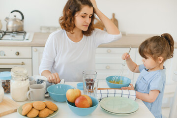 A young mother spends time with her little daughter at home.