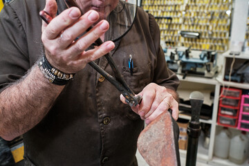 shoemaker man working in his shoe shop with mask