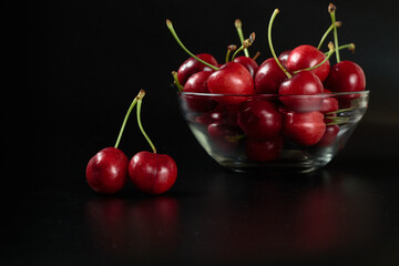 Fototapeta na wymiar Spring red cherries on black background selective focus cherry