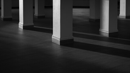 Base of square pillars group with sunlight and shadow on surface of wooden tile floor in black and...