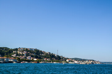 Naklejka na ściany i meble Houses on the coast of the Bosphorus strait. Beautiful view of coastline in Istanbul with luxury residential buildings and cater boats