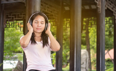 pretty girl listen to music with wireless earphone in garden to relax