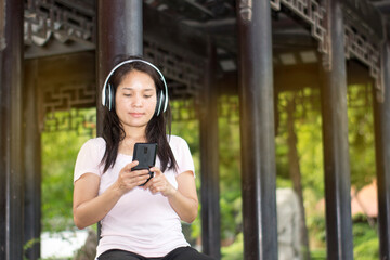 pretty girl listen to music with wireless earphone in garden to relax