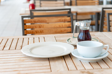 テラスのテーブルに置かれた皿とコーヒーカップ　カフェのモーニングのイメージ