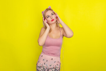 Blonde woman in summer clothing wearing pink headphones