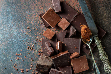 Dark and milk chocolate on a concrete background.