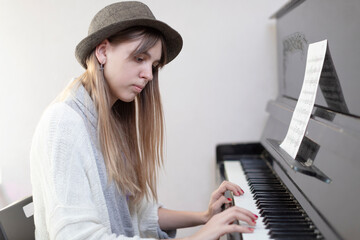 Photo of a young girl playing the piano at home.