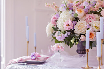Wedding table decor. Beautiful bouquet with roses and peonies. Lace tablecloth and candles in candlesticks