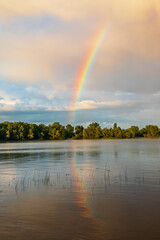 Rainbow after the summer rain over the river.