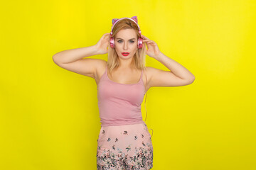Blonde woman in summer clothing wearing pink headphones