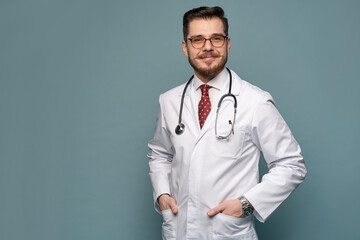 A portrait of a medical doctor posing against gray background