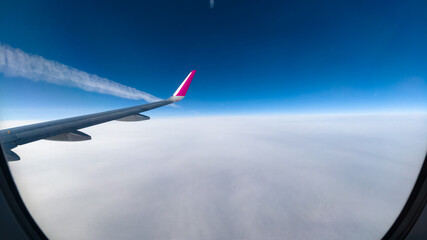 Fototapeta premium Inversion trail of an airplane above the clouds.