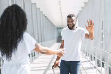Obraz premium Happy Afro Man Greeting His Girlfriend After Arrival At Airport