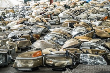 Used headlamp components for sale at scrapyard area