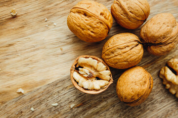 Unpeeled walnuts on wooden surface, closeup. View from above. Food photo. Selective focus.