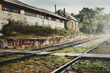 Abandoned Industrial Building On Background Of Railway Stretching Into The Distance