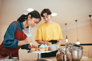 Two happy bakers decorating a mini cheesecake