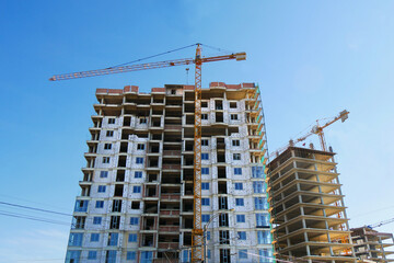 Construction site. High-rise multi-storey buildings under construction. Tower cranes near buildings.