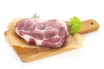 Raw pork steak over wooden board