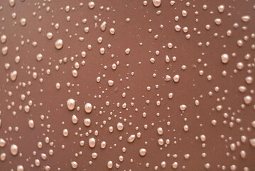 drops of water on a brown metal surface