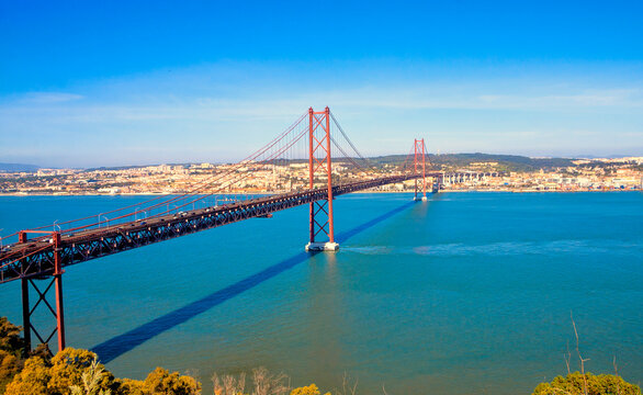  25th of April Bridge (Ponte 25 de Abril) on Tagus river in Lisbon, Portugal. Red bridge. Famous landmarks of Lisbon.