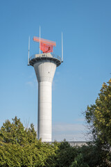 white and red radar tower, against a blue sky